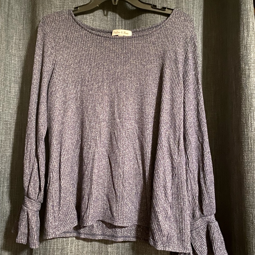Blue sweater with tie detail on sleeves.